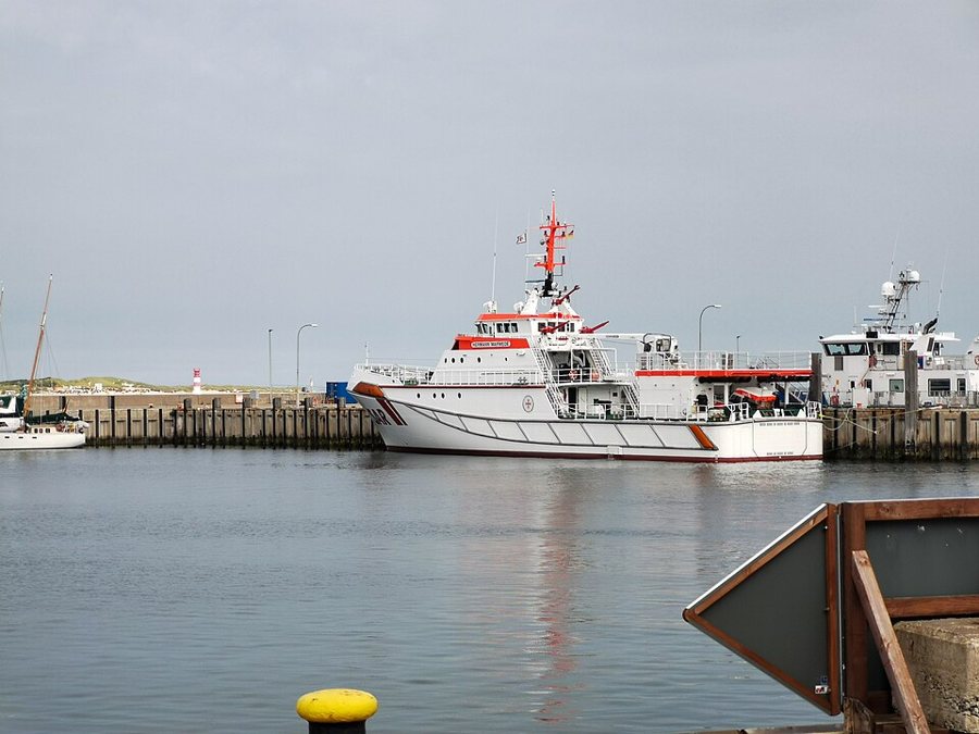 Der große, orangeweiße Seenotrettungskreuzer HERMANN MARWEDE liegt im Hafen von Helgoland.