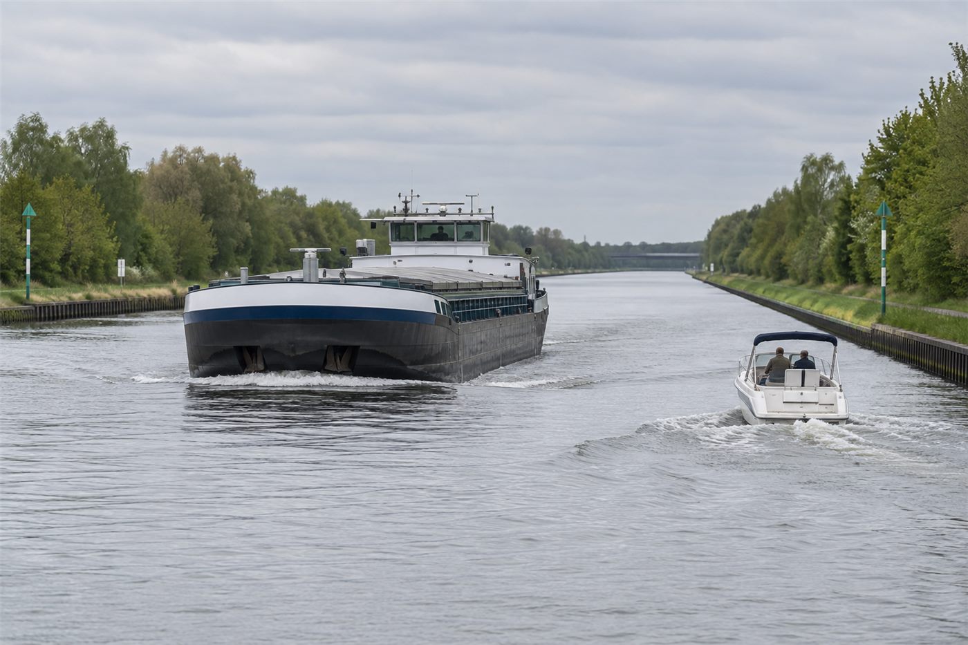 Schiffsverkehr im Kanal - Berufsschiff und Sportboot mit sicherem Abstand.