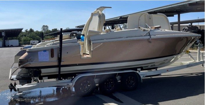Das gekenterte und geborgene Sportboot auf einem Trailer, Seitenansicht.