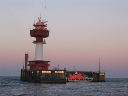 Foto: rot-weißer Leuchtturm in der Abenddämmerung